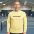 Man wearing a yellow shirt with 'PEPINI' logo on an indoor tennis court